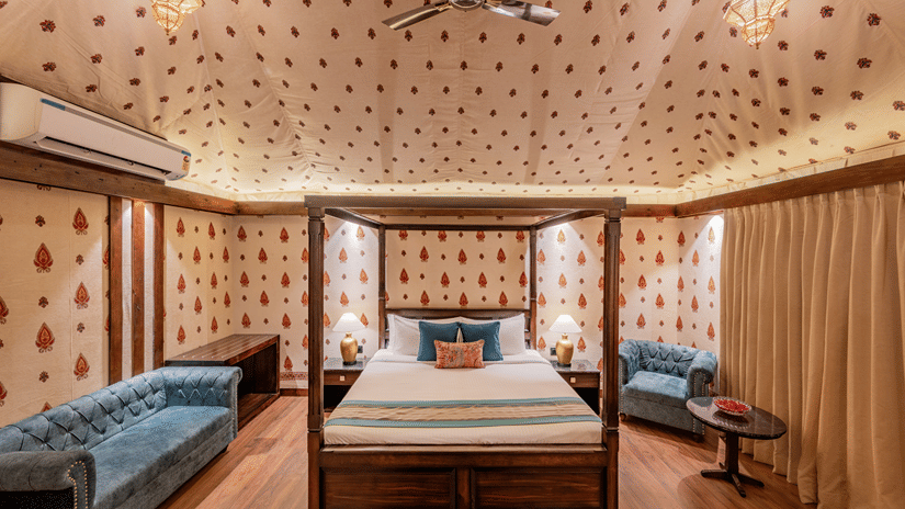 A premium tent with a cosy bed , flanked by pendent lantern lights on the sides  at Ananta Spa And Resort, Pushkar