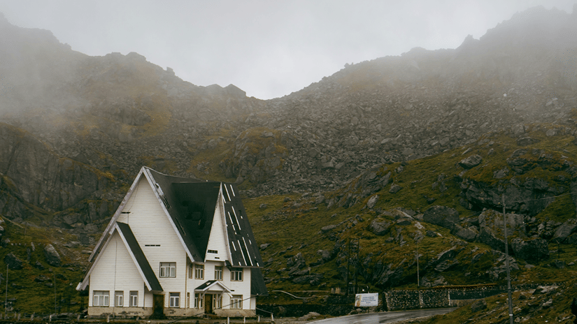 A house on way to Nathula Pass, one of the Gangtok tourist places, with rocky mountains in the background