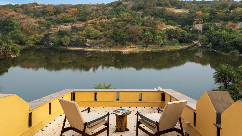 2 chairs and a small table on a balcony facing a lake - Chunda Shikar Oudi, Udaipur