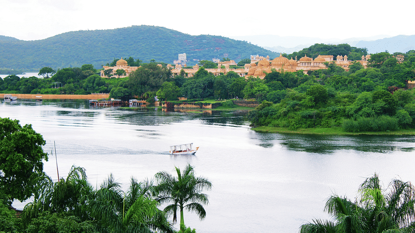 An overview of Lake Pichola with the City Palace and a mountain in the background.