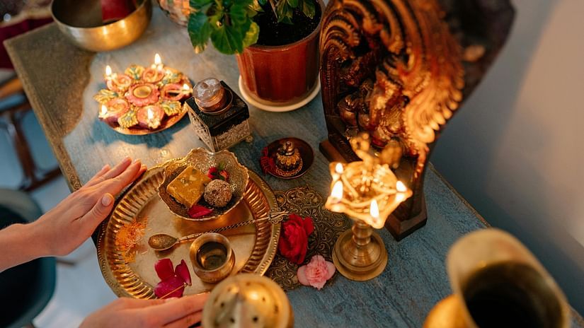 Sweets being offered to the lord alongside a plate of aarti