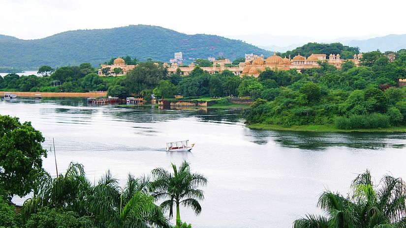 an overview of Lake Pichola with a palace and a mountain in the background