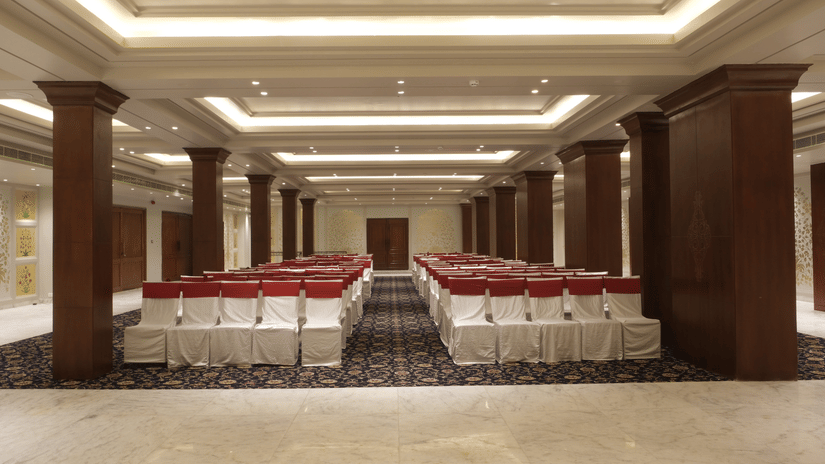 The Swarn Mahal with theatre-style seating, wooden columns, ambient lighting, and spacious interiors prepared for wedding functions and social events | Clarks Amer, Jaipur