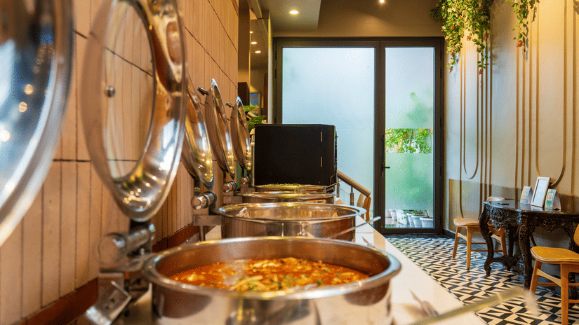 Buffet spread at Cosy Grand @Chanakyapuri by The Cosy Hotels with warm food served in steel chafing dishes.