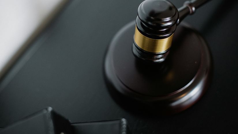 A close-up of a judge's gavel on a dark surface