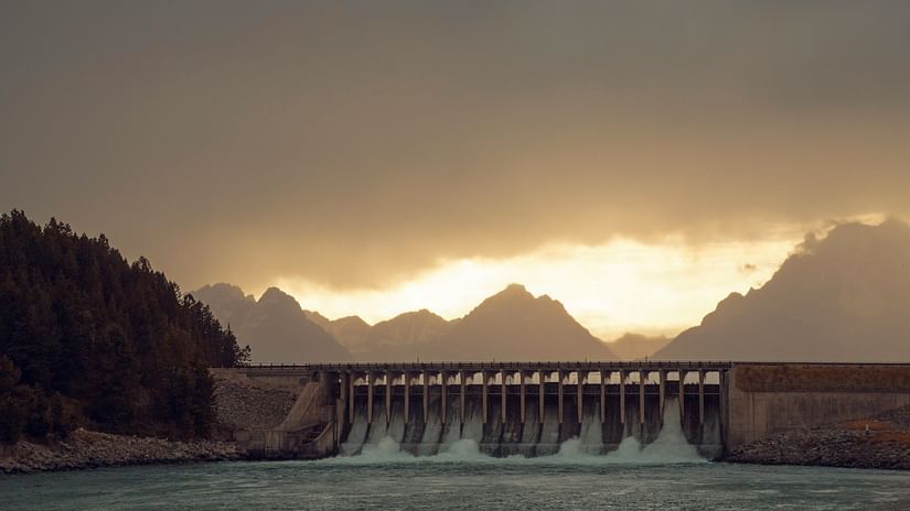 overview of a dam with water gushing from the pathways and evening sky in the background