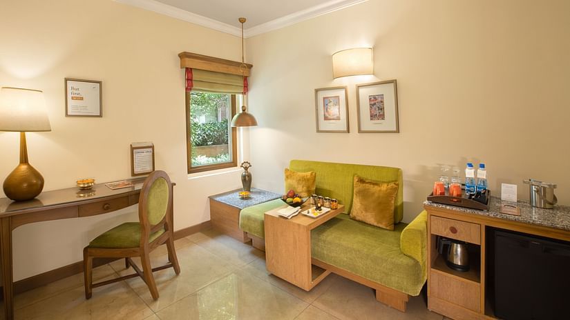 heritage superior rooms in manesar featuring a plush sofa, work desk chair and other amenities