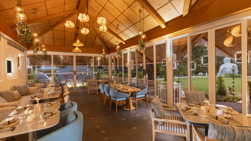 Elegant indoor dining area with warm lighting, high ceiling, and stylish furnishings.