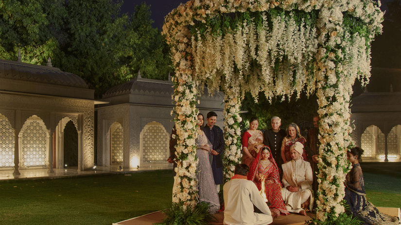 A traditional Indian wedding ceremony at night, with the bride and groom under a beautifully decorated floral canopy at Heritage Village Resorts & Spa, Manesar - One of the best Destination Wedding Venues Near Delhi.
