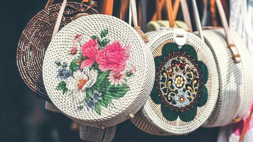a close up shot of women's handbags hung outside a shop