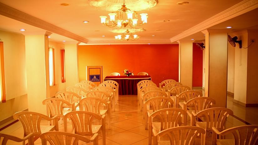 a row of chairs placed in front of podium at a conference hall in Hotel Swagath Bangalor