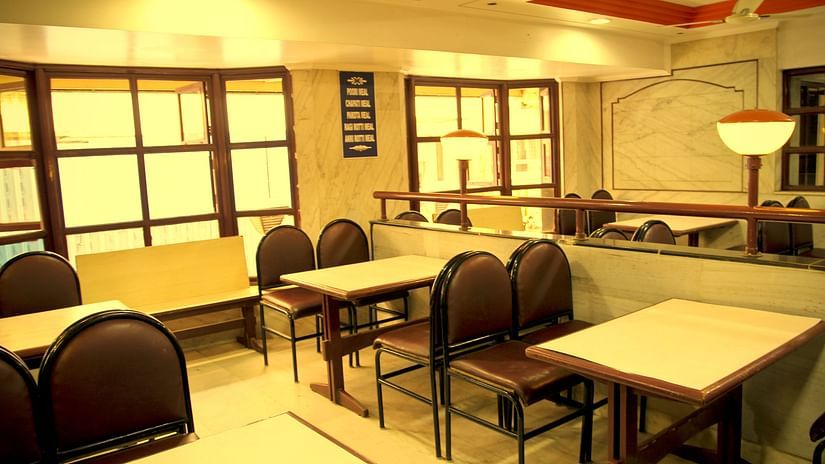 a view of a restaurant arrayed with plush seating arrangements at Hotel Swagath, Bangalore