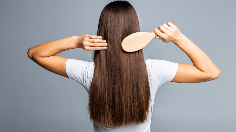 rear-view-combing-healthy-long-straight-female-hair-isolated-gray