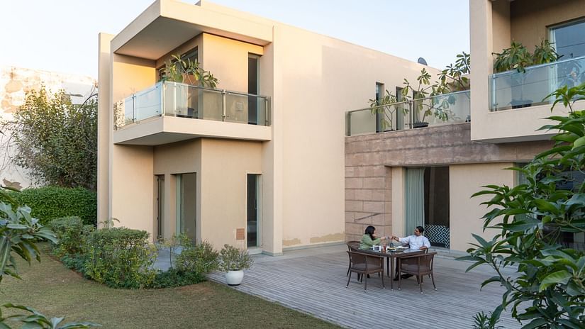 Facade view of the Humming Bird Villa with trees next to it at Karma Lakelands 