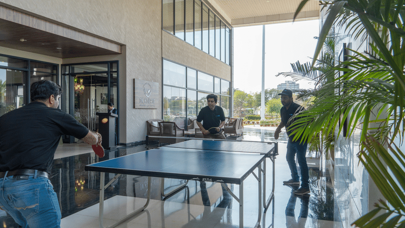 Three people playing table tennis in a modern indoor area at Karma Lakelands