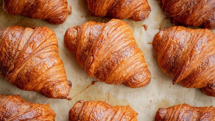 Aerial view of many croissants placed next to each other after they are baked