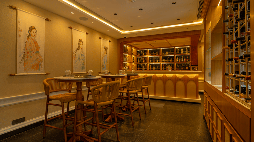 Elegant interiors of VietNom restaurant featuring warm lighting, wooden seating, a stylish bar, and an extensive wine display | Kenilworth Hotel, Kolkata