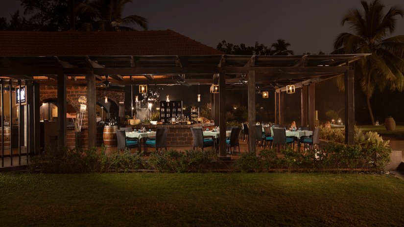 Due Amici, the Italian restaurant at Kenilworth Resort & Spa, Goa, lit up in the night featuring seating arrangement