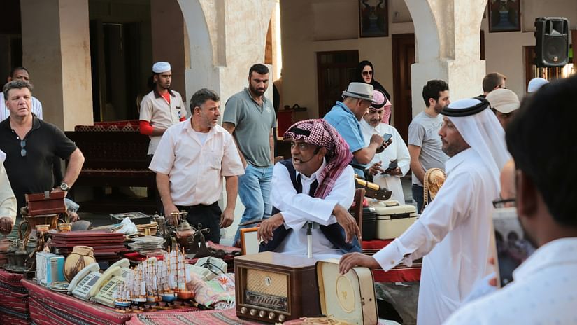 A vibrant Souq Waqif in Qatar with people moving from one stall to another shopping