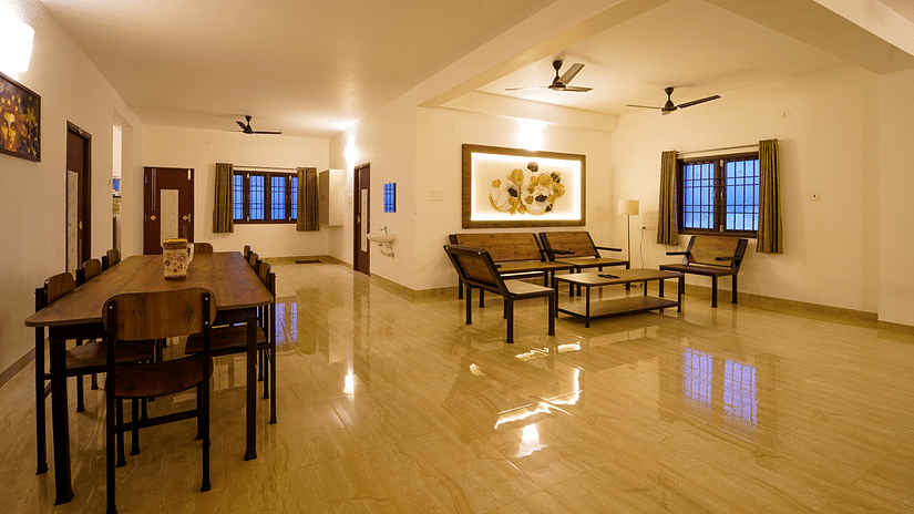 Living area with seating arrangements of sofas and coffee table and dinign area inside Superior Villa - La Tamara Luxury, Pondicherry