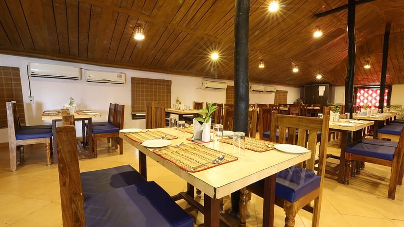 A dining setup with wooden furnished table and chair- Lotus Eco Beach Resort, Konark.