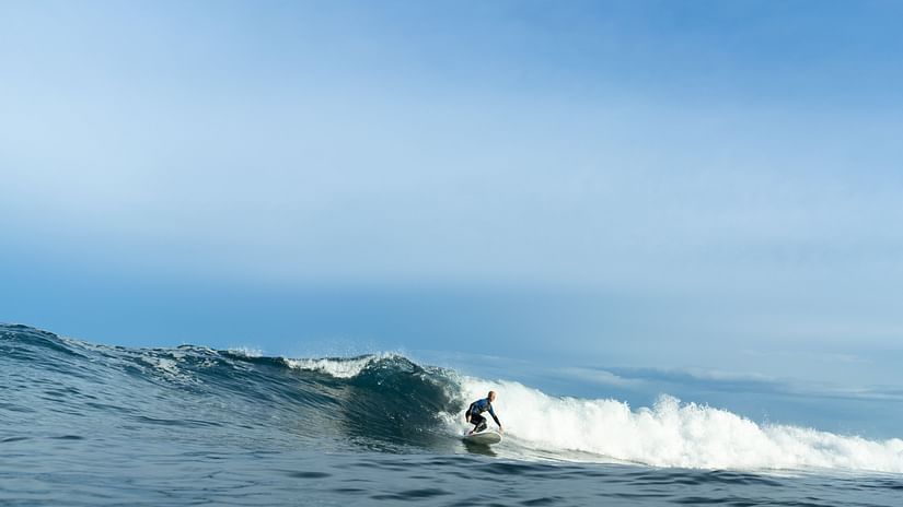 A long shot of person surfing in the sea