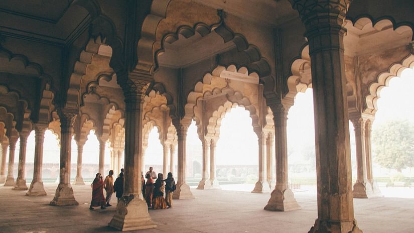 A group of people standing near pillars of a building