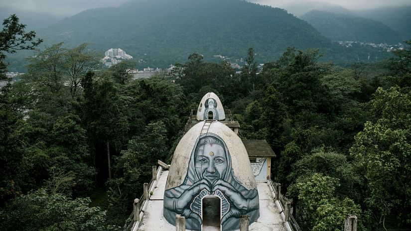A traditional dome surrounded by trees and hills in the background.