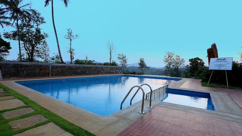 An overview of the Swimming pool with trees in the distance - Parisons Plantation Experiences by Abad