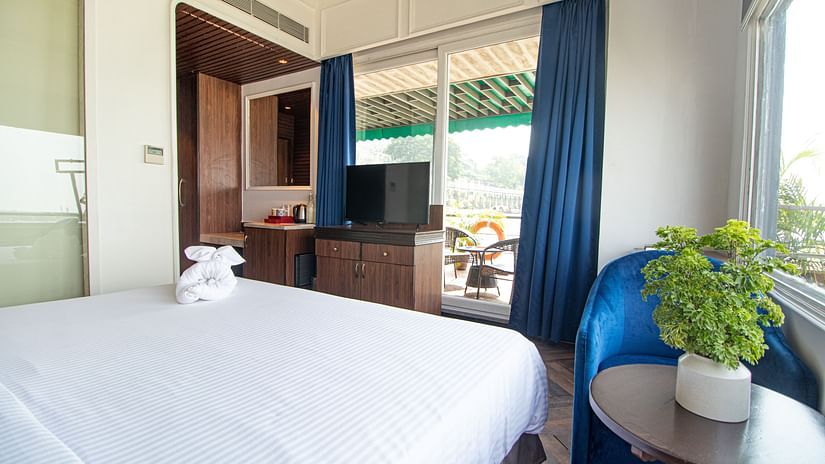 a well made bed facing the window  - polo floatel kolkata