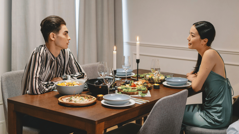 A couple enjoying a fine dining experience at Pride Hotel Delhi, seated at an elegantly arranged table with gourmet cuisine in a warm and sophisticated restaurant setting.