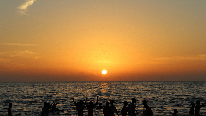 beach sunset view - a beautiful orange sun dipping into the still waters.