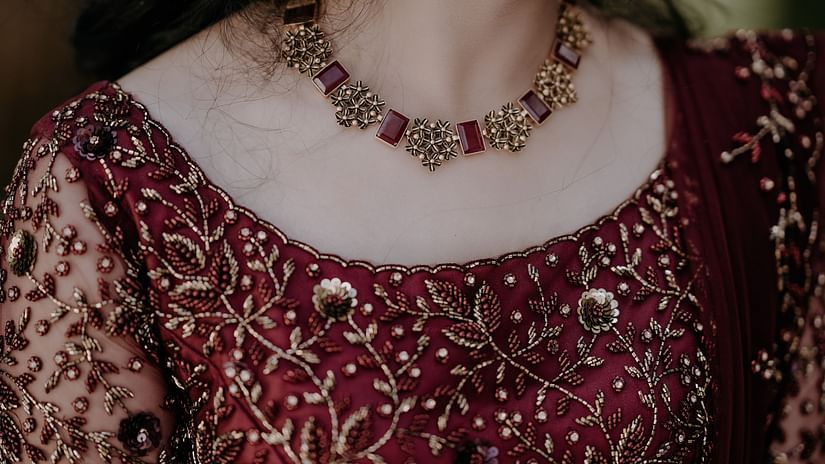 a close up shot of a Woman wearing traditional style necklace