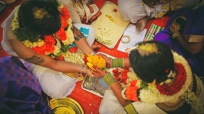 Bride and groom at the mandapam during the marriage based on the auspicious wedding dates, 2026, holding a coconut in their palms