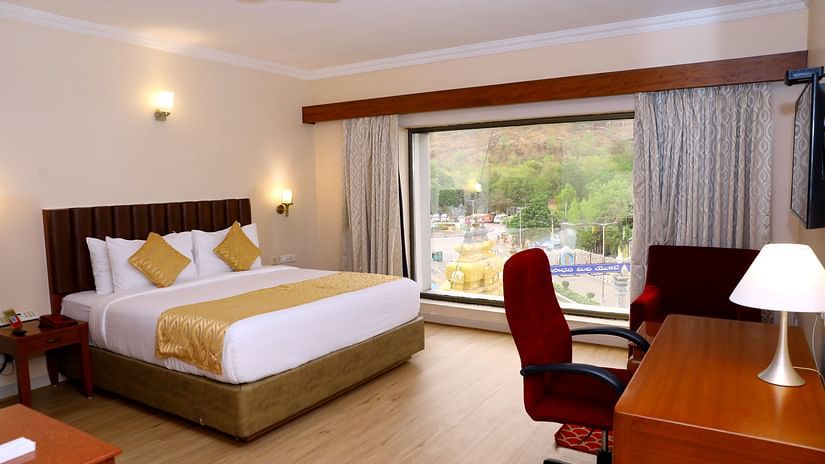 Bedroom with large window and desk chair.