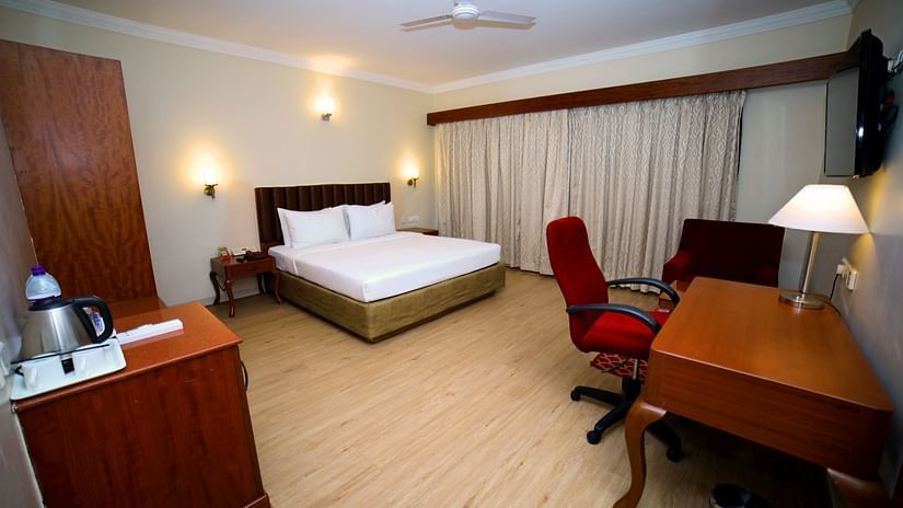 Bedroom with bed, desk, and red chair.