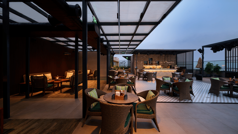 Covered rooftop dining area at Riviera Sarovar Portico, Pathankot with outdoor seating and a pleasant evening ambience.