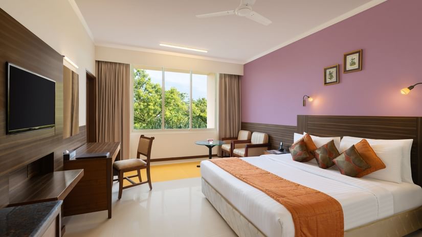 Double bed and a television inside the Family Room at Sangam Hotel for the ideal Rooms Near Thanjavur Railway Station