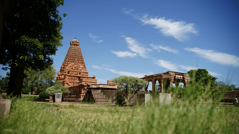 A far out view of Brihadeswara Temple in Thanjavur with green grass in the foreground - Sightseeing in Thanjavur.