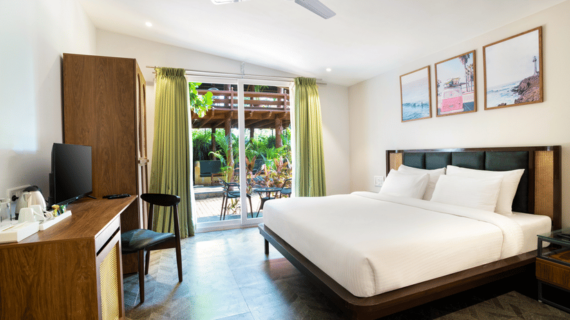 image of the tropical classic cottage highlighting the queen size bed along with an elegant french window at the corner of the room