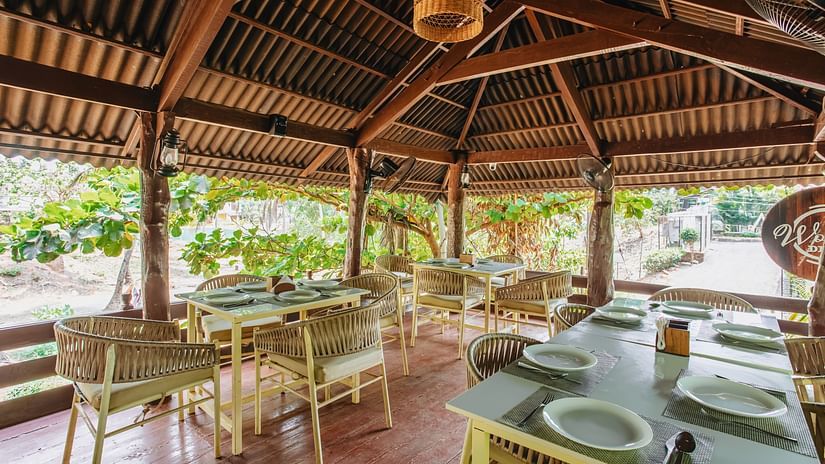 image of the wooden deck with covered seating arrangement surrounded by lush tropical greenery at sibaya beach resort, morjim beach