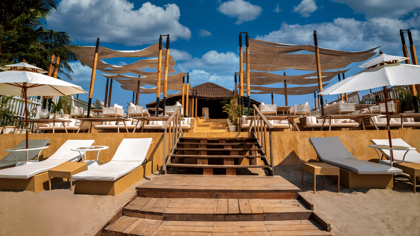 The front view of the entrance of the In-House Restaurant featuring white coloured sun loungers at the entrance
