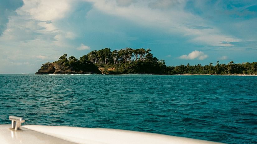 A scenic view of an island from a water body. 