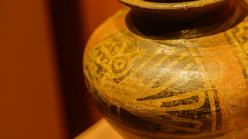 A close-up shot of a large, old, decorated ceramic pot with a wide rim.