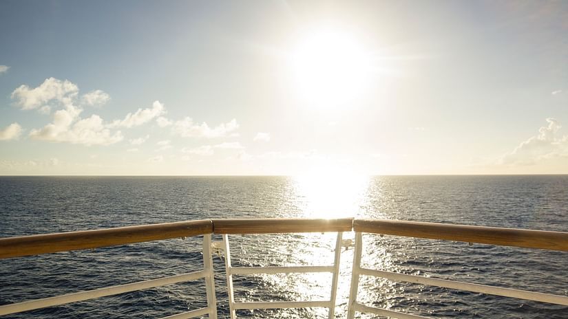 brown and white railing of a cruise ship overlooking the ocean