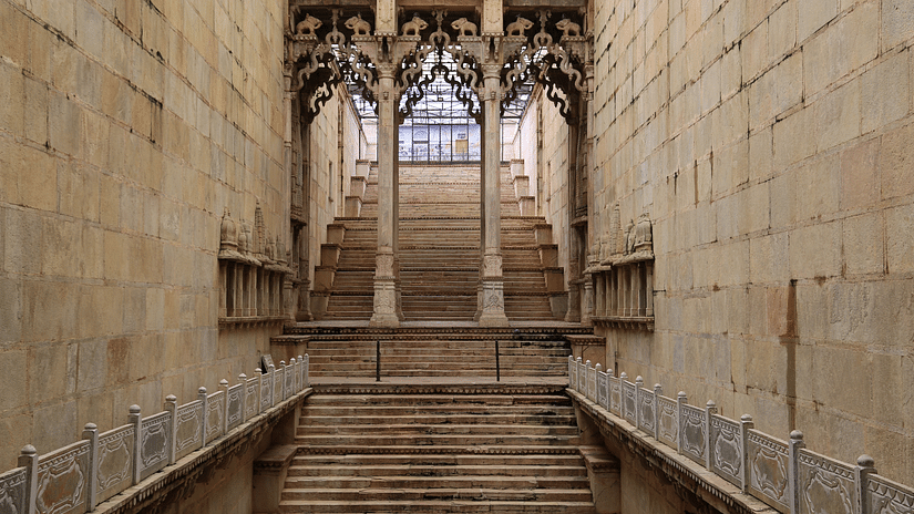 Steps leading up with columns having intricate carvings inside a building in Bundi