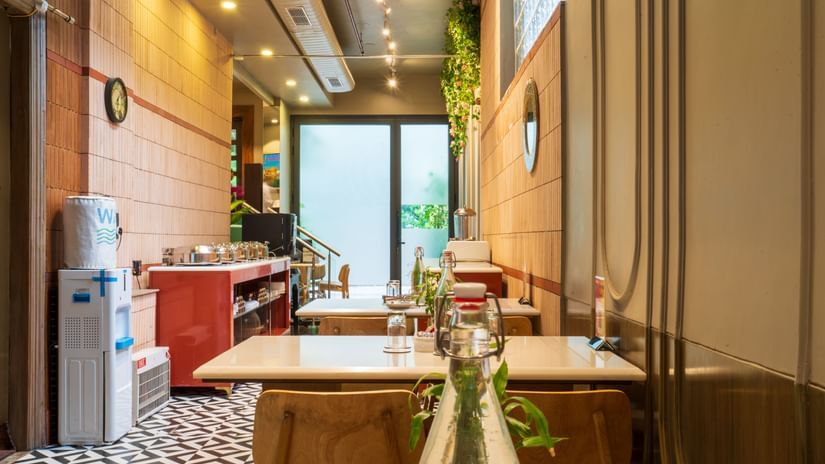 Hotel dining area with elegant seating, bright lighting, and a stylish setup offering a warm ambience.