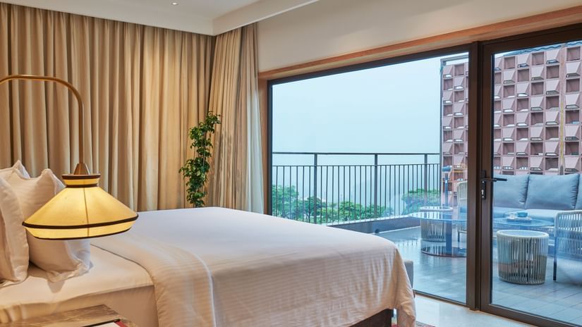 A room with an attached balcony overlooking greenery and sitting area at The Dukes Retreat.