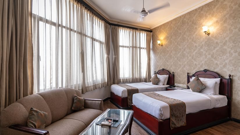 An image of a large bedroom, with two large  windows, and a sitting area  - The Lindsay
