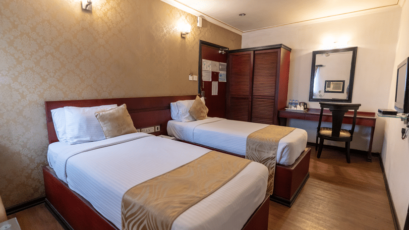 An image of a bedroom with two single size beds - The Lindsay